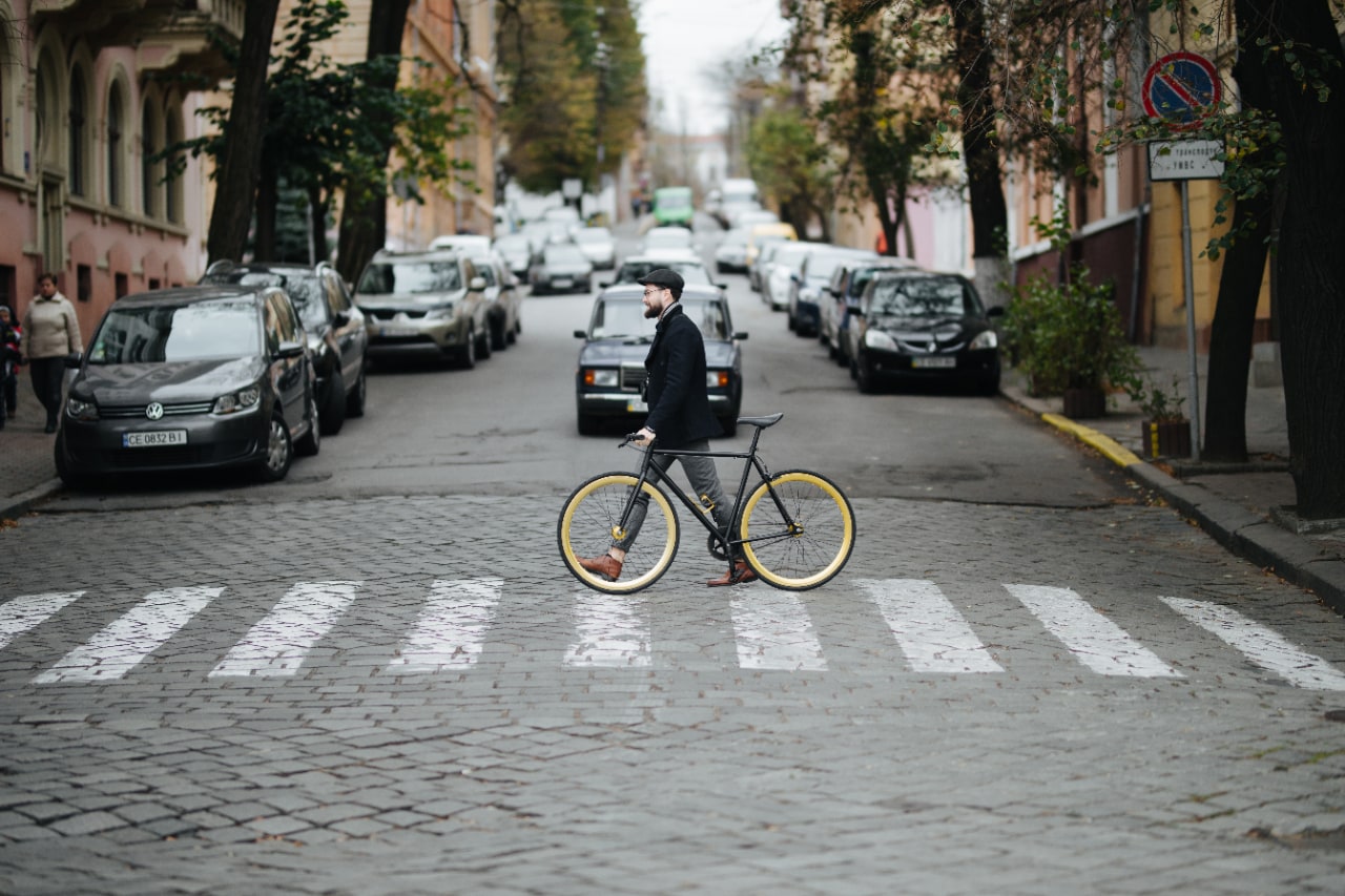 Young man walking across the city street